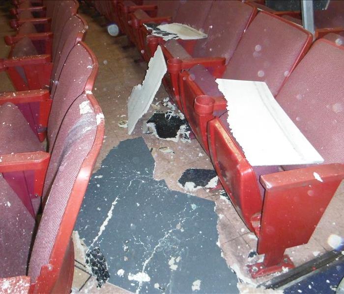 Red seats in a movie theater covered in debris