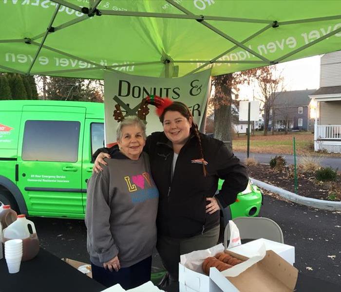 2 females standing under a green tent